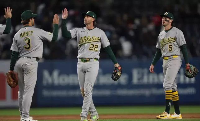 The Athletics' including Max Muncy (3) and Jeff McNeil (22) celebrate a win after the ninth inning of a baseball game against the New York Yankees, Wednesday, April 8, 2026, in New York. (AP Photo/Heather Khalifa)
