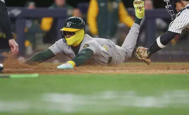 Athletics' Lawrence Butler slides home to score during the fourth inning of a baseball game against the New York Yankees, Wednesday, April 8, 2026, in New York. (AP Photo/Heather Khalifa)