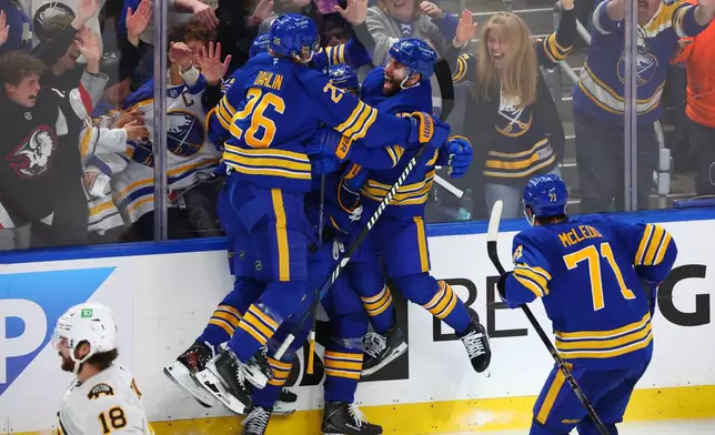 Buffalo Sabres players celebrate a goal by defenseman Mattias Samuelsson (23) during the third period in Game 1 of a first-round NHL hockey Stanley Cup playoff series against the Boston Bruins, Sunday, April 19, 2026, in Buffalo, N.Y. (AP Photo/Jeffrey T. Barnes)