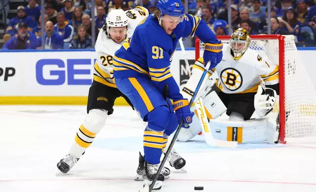 Buffalo Sabres right wing Josh Doan (91) carries the puck past Boston Bruins defenseman Andrew Peeke (26) during the first period in Game 1 of a first-round NHL hockey Stanley Cup playoff series Sunday, April 19, 2026, in Buffalo, N.Y. (AP Photo/Jeffrey T. Barnes)
