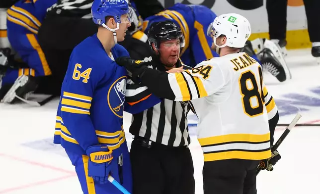 Buffalo Sabres defenseman Logan Stanley (64) and Boston Bruins left wing Tanner Jeannot (84) are separated during the third period in Game 1 of a first-round NHL hockey Stanley Cup playoff series, Sunday, April 19, 2026, in Buffalo, N.Y. (AP Photo/Jeffrey T. Barnes)