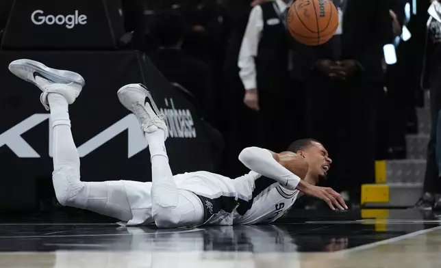 San Antonio Spurs forward Victor Wembanyama (1) takes a hard fall on the court during the first half in Game 2 of a first-round NBA playoffs basketball series against the Portland Trail Blazers in San Antonio, Tuesday, April 21, 2026. (AP Photo/Eric Gay)