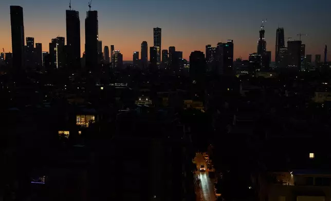 A car moves down a street in the early morning in Tel Aviv, Israel, Wednesday, April 22, 2026, following the announcement by U.S. President Donald Trump that he was extending the ceasefire with Iran. (AP Photo/Leo Correa)