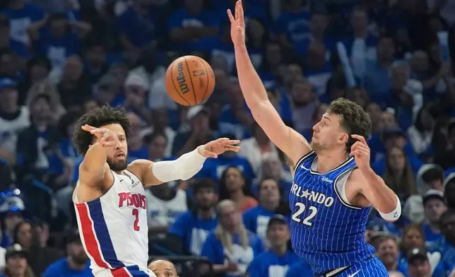 Detroit Pistons guard Cade Cunningham (2) passes the ball past Orlando Magic forward Franz Wagner (22) during the second half in Game 4 of a first-round NBA basketball playoff series, Monday, April 27, 2026, in Orlando, Fla. (AP Photo/John Raoux)