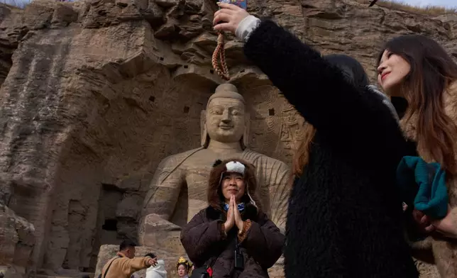 FILE - Tourists visit the Yungang Grottoes in Datong, China, Friday, March 13, 2026. (AP Photo/Ng Han Guan, File)