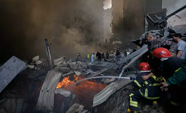 FILE - Firefighters try to put out flames at the site of an Israeli airstrike that struck an apartment building in Beirut, Lebanon, Wednesday, April 8, 2026. (AP Photo/Bilal Hussein, File)