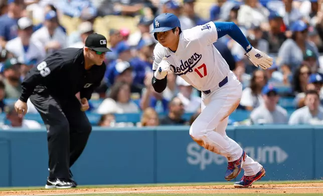Los Angeles Dodgers designated hitter Shohei Ohtani (17) runs to home plate to score off a sacrifice fly hit by Dodgers' Andy Pages during the first inning of a baseball game against the Chicago Cubs, Sunday, April 26, 2026, in Los Angeles. (AP Photo/Caroline Brehman)