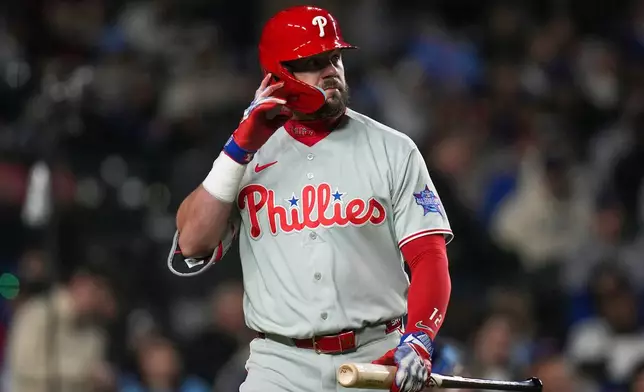 Philadelphia Phillies' Kyle Schwarber (12) returns to the dugout after striking out during the seventh inning of a baseball game against the Chicago Cubs, Wednesday, April 22, 2026, in Chicago. (AP Photo/Erin Hooley)