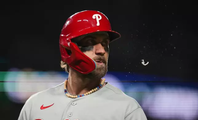 Philadelphia Phillies designated hitter Bryce Harper (3) returns to the dugout after grounding out during the eighth inning of a baseball game against the Chicago Cubs, Wednesday, April 22, 2026, in Chicago. (AP Photo/Erin Hooley)