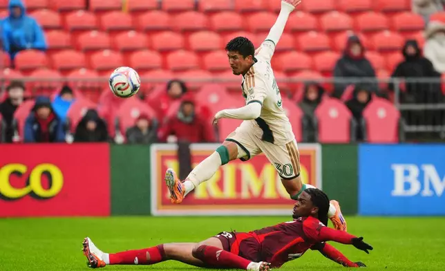 Atlanta United's Cayman Togashi (30) shoots at goal as Toronto FC's Zane Monlouis (12) defends during the first half of an MLS soccer game in Toronto, Saturday, April 25, 2026. (Frank Gunn/The Canadian Press via AP)