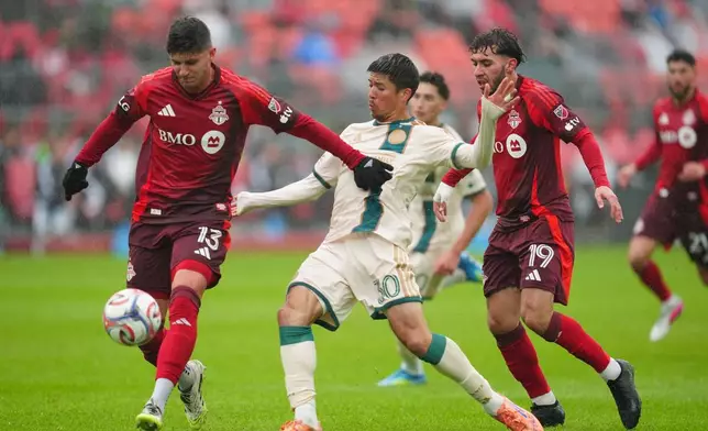 Toronto FC's Benjamín Kuscevic, left, and Atlanta United's Cayman Togashi battle for the ball during the first half of an MLS soccer game in Toronto, Saturday, April 25, 2026. (Frank Gunn/The Canadian Press via AP)