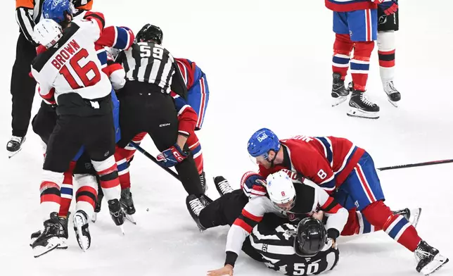 Players from the New Jersey Devils and Montreal Canadiens scuffle during the third period of an NHL hockey game in Montreal, Sunday, April 5, 2026. (Graham Hughes/The Canadian Press via AP)