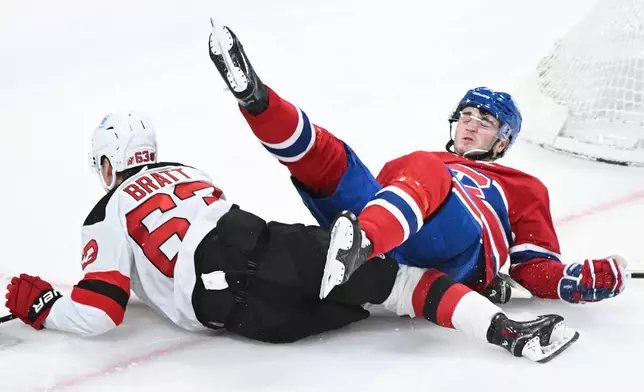 New Jersey Devils' Jesper Bratt (63) collides with Montreal Canadiens' Noah Dobson during the second period of an NHL hockey game in Montreal, Sunday, April 5, 2026. (Graham Hughes/The Canadian Press via AP)
