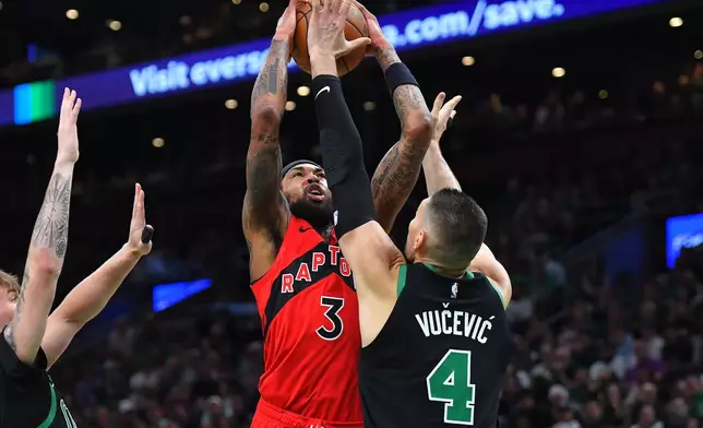 Toronto Raptors forward Brandon Ingram (3) takes a shot at the basket as Boston Celtics center Nikola Vucevic (4) defends in the first half of an NBA basketball game, Sunday, April 5, 2026, in Boston. (AP Photo/Steven Senne)