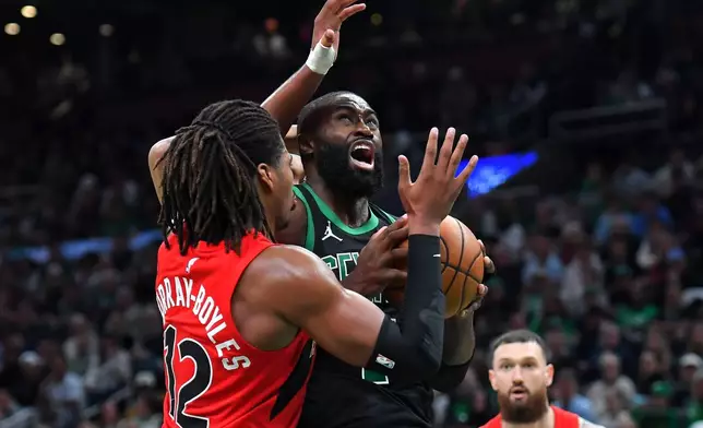 Boston Celtics guard Jaylen Brown drives toward the basket as Toronto Raptors forward Collin Murray-Boyles, left, defends in the second half of an NBA basketball game, Sunday, April 5, 2026, in Boston. (AP Photo/Steven Senne)