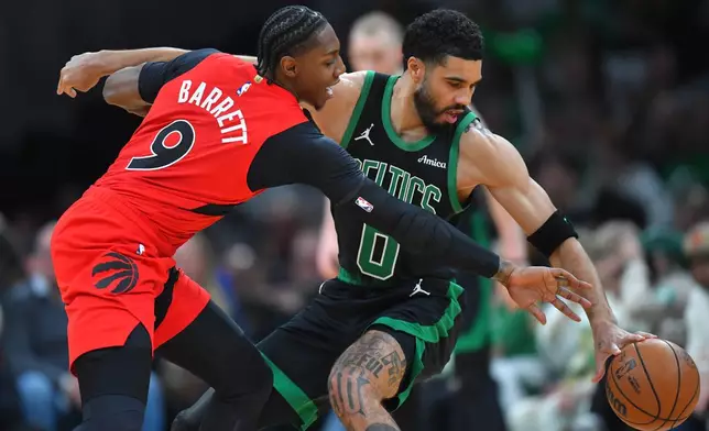 Boston Celtics forward Jayson Tatum, right, tries to drive past Toronto Raptors forward RJ Barrett in the first half of an NBA basketball game, Sunday, April 5, 2026, in Boston. (AP Photo/Steven Senne)