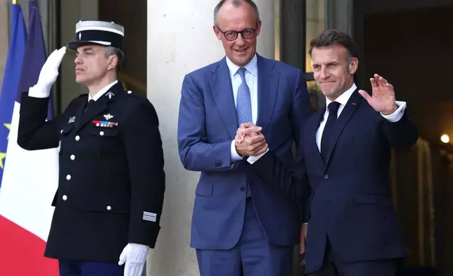 French President Emmanuel Macron, right, greets German Chancellor Friedrich Merz ahead of a multinational virtual summit at the Elysee Presidential Palace in Paris, Friday April 17, 2026 (Tom Nicholson/Pool Photo via AP)