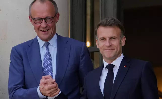 France's President Emmanuel Macron, right, welcomes German Chancellor Friedrich Merz prior to an international summit to push forward efforts to reopen the Strait of Hormuz, at the Elysee Palace, in Paris, France, Friday, April 17, 2026. (AP Photo/Michel Euler)