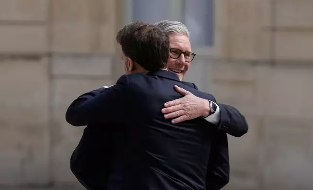 France's President Emmanuel Macron, seen from behind, welcomes British Prime Minister Keir Starmer prior to an international summit to push forward efforts to reopen the Strait of Hormuz, at the Elysee Palace, in Paris, France, Friday, April 17, 2026. (AP Photo/Michel Euler)