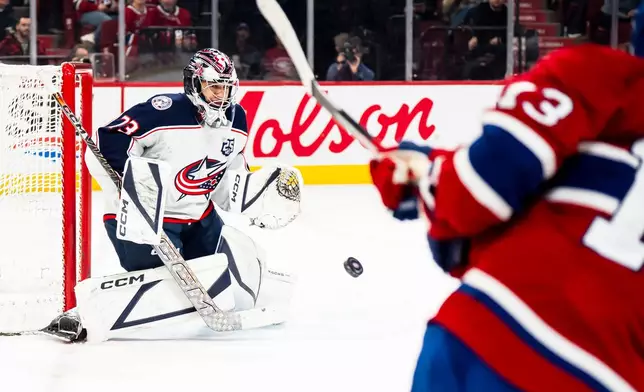 Columbus Blue Jackets' Jet Greaves (73) makes a save against Montreal Canadiens' Cole Caufield (13) during first-period NHL hockey game action in Montreal, Saturday, April 11, 2026. (Christopher Katsarov/The Canadian Press via AP)