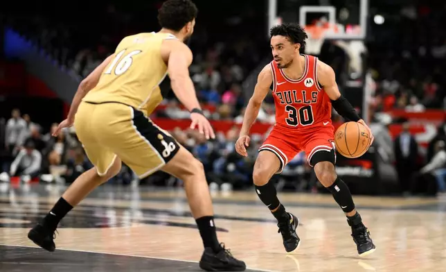 Chicago Bulls guard Tre Jones (30) dribbles against Washington Wizards forward Anthony Gill (16) during the first half of an NBA basketball game, Thursday, April 9, 2026, in Washington. (AP Photo/Nick Wass)