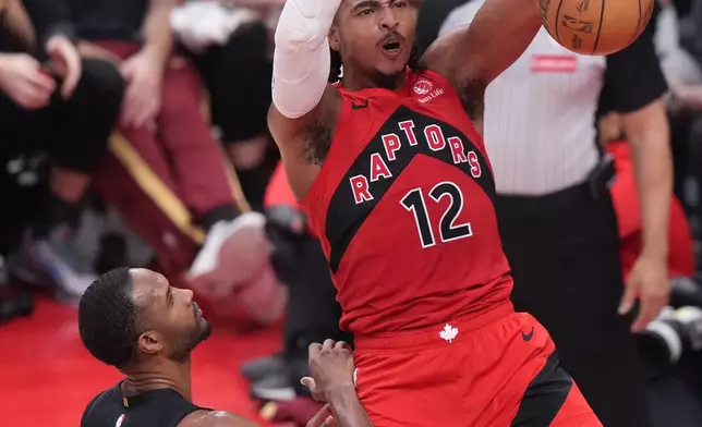 Toronto Raptors forward Collin Murray-Boyles (12) dunks as Cleveland Cavaliers center Evan Mobley (4) watches during the first half of Game 4 in a first-round NBA basketball playoffs series in Toronto, Sunday, April 26, 2026. (Nathan Denette/The Canadian Press via AP)