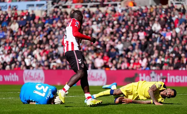 Sunderland's Brian Brobbey, centre, looks on after pushing Tottenham Hotspur's Cristian Romero, right, into Tottenham Hotspur goalkeeper Antonin Kinsky, left, during the Premier League soccer match between Sunderland and Tottenham Hotspur, in Sunderland, England, Sunday April 12, 2026. (Owen Humphreys/PA via AP)