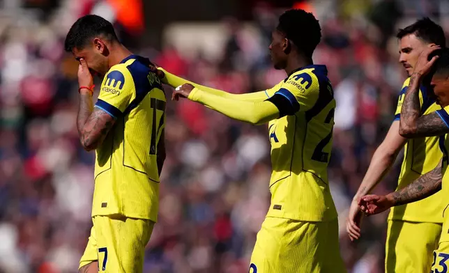 Tottenham Hotspur's Cristian Romero, left, leaves the field after colliding with his team mate Tottenham Hotspur goalkeeper Antonin Kinsky during the Premier League soccer match between Sunderland and Tottenham Hotspur, in Sunderland, England, Sunday April 12, 2026. (Owen Humphreys/PA via AP)