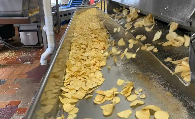Potato chips move along a conveyor at a Better Made Snack Foods processing facility in Detroit, on Thursday, April 2, 2026 (AP Photo/Mike Householder)