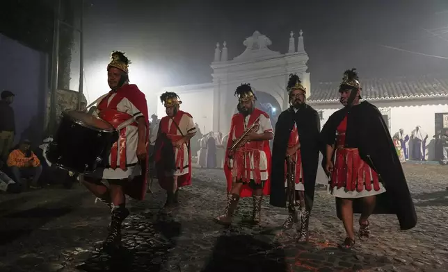 Musicians dressed as Roman soldiers take part in La Merced church's Good Friday procession during Holy Week in Antigua, Guatemala, Friday, April 3, 2026. (AP Photo/Moises Castillo)