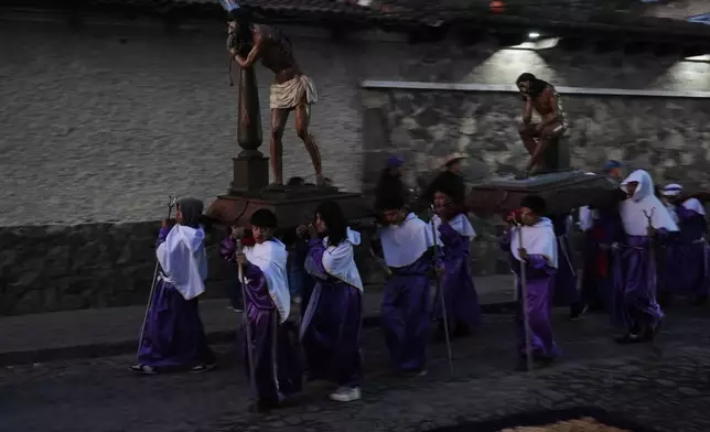 Penitents carry statues of Jesus Christ representing the Stations of the Cross at a Good Friday procession by La Merced church during Holy Week in Antigua, Guatemala, just before sunrise Friday, April 3, 2026. (AP Photo/Moises Castillo)
