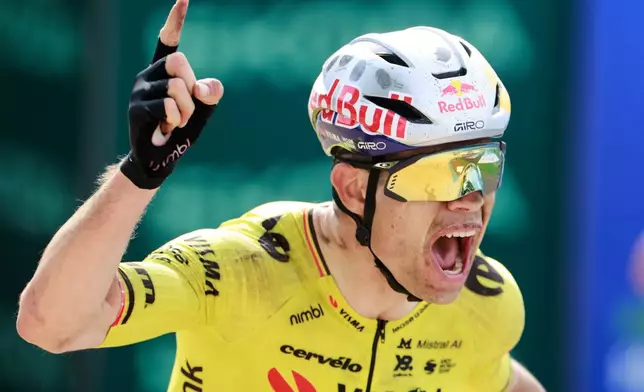 Belgium's Wout van Aert crosses the finish line to win the Paris-Roubaix cycling race in Roubaix, France, Sunday, April 12, 2026. (AP Photo/Jean-Francois Badias)