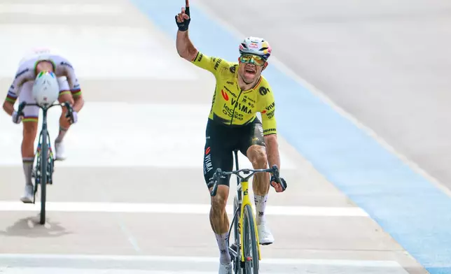 Belgium's Wout van Aert crosses the finish line ahead of Tadej Pogacar of Slovenia, left, to win the Paris-Roubaix cycling race in Roubaix, France, Sunday, April 12, 2026. (AP Photo/Jean-Francois Badias)