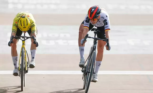 Franziska Koch of Germany, right, crosses the finish line ahead of Marianne Vos of the Netherlands to win the women's Paris-Roubaix Femmes cycling race in Roubaix, France, Sunday, April 12, 2026. (AP Photo/Jean-Francois Badias)