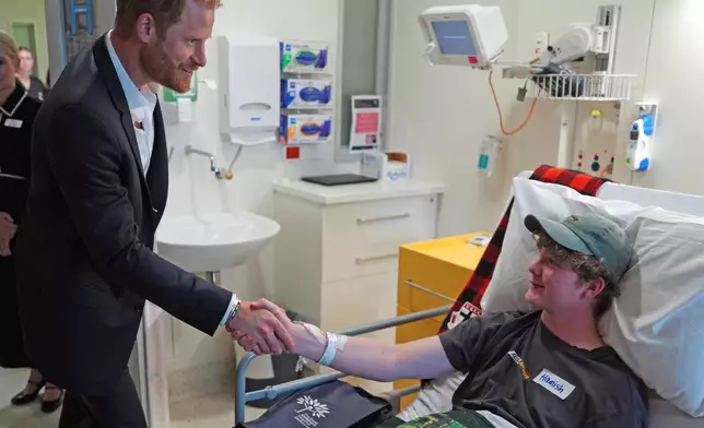 Britain's Prince Harry, the Duke of Sussex, meets patient Hamish on the Adolescent Oncology and Rehabilitation ward during a visit to the Royal Children's Hospital Melbourne, Australia Tuesday, April 14, 2026. (Jonathan Brady/Pool Photo via AP)