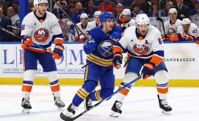 Buffalo Sabres center Peyton Krebs (19) skates between New York Islanders center Marc Gatcomb (16) and defenseman Ryan Pulock (6) during the first period of an NHL hockey game Tuesday, March 31, 2026, in Buffalo, N.Y. (AP Photo/Jeffrey T. Barnes)