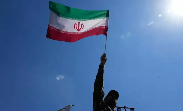 A government supporter waves an Iranian flag during a gathering in Tehran, Iran, Thursday, April 9, 2026. (AP Photo/Vahid Salemi)