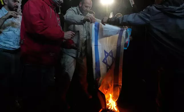 Iranian pro-government demonstrators burn an Israeli flag during a gathering after announcement of a two-week ceasefire in the war with the United States and Israel, at the Enqelab-e-Eslami, or Islamic Revolution, Square, in Tehran, Iran, Wednesday, April 8, 2026. (AP Photo/Vahid Salemi)