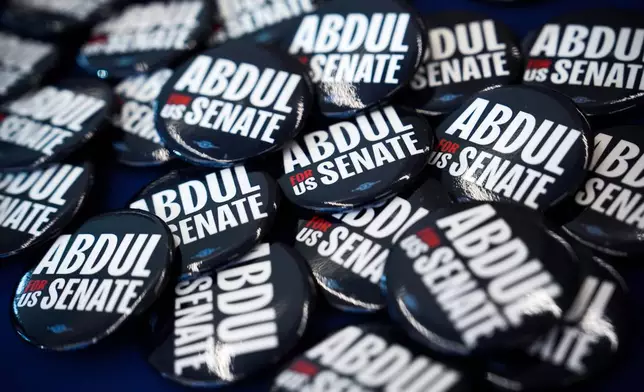 Buttons lay on a table before a campaign event with streamer Hasan Piker and Abdul El-Sayed, a progressive candidate in the Democratic primary for U.S. Senate in Michigan, Tuesday, April 7, 2026, at the University of Michigan in Ann Arbor, Mich. (AP Photo/Julia Demaree Nikhinson)