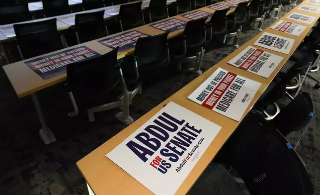 Posters lay on lecture hall tables before a campaign event with streamer Hasan Piker and Abdul El-Sayed, a progressive candidate in the Democratic primary for U.S. Senate in Michigan, Tuesday, April 7, 2026, at the University of Michigan in Ann Arbor, Mich. (AP Photo/Julia Demaree Nikhinson)