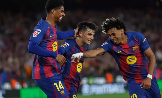 Barcelona's Marcus Rashford, left, celebrates after scoring his side's fourth goal with Lamine Yamal, right, and Pedri during the Spanish La Liga soccer match between Barcelona and Espanyol in Barcelona, Spain, Saturday, April 11, 2026. (AP Photo/Joan Monfort)