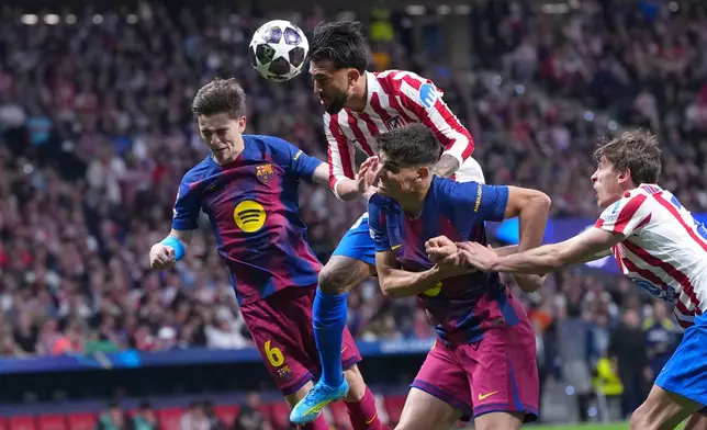 Atletico Madrid's Nicolas Gonzalez, top, heads the ball during the Champions League quarterfinal second leg soccer match between Atletico Madrid and Barcelona in Madrid, Spain, Tuesday, April 14, 2026. (AP Photo/Manu Fernandez)
