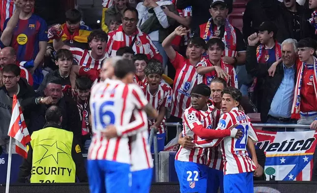 Atletico Madrid's Ademola Lookman celebrates with teammates after scoring his side's opening goal during the Champions League quarterfinal second leg soccer match between Atletico Madrid and Barcelona in Madrid, Spain, Tuesday, April 14, 2026. (AP Photo/Manu Fernandez)