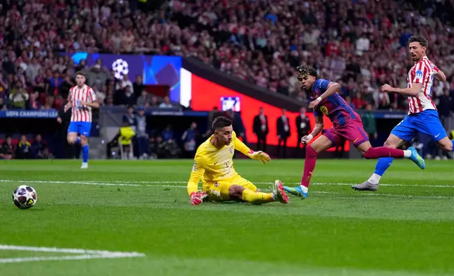 Barcelona's Lamine Yamal, center, scores the opening goal during the Champions League quarterfinal second leg soccer match between Atletico Madrid and Barcelona in Madrid, Spain, Tuesday, April 14, 2026. (AP Photo/Manu Fernandez)