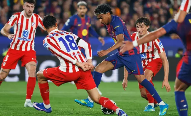 Barcelona's Lamine Yamal challenges for the ball with Atletico Madrid's Marc Pubill during the Champions League quarterfinal first leg soccer match between Barcelona and Atletico Madrid in Barcelona, Spain, Wednesday, April 8, 2026. (AP Photo/Joan Monfort)