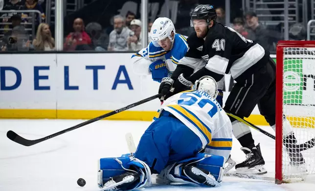 Los Angeles Kings right wing Joel Armia (40) and St. Louis Blues defenseman Cam Fowler (17) vie for the puck during the second period of an NHL hockey game, Wednesday, April 1, 2026, in Los Angeles. (AP Photo/Kyusung Gong)
