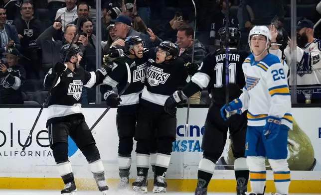 Los Angeles Kings left wing Trevor Moore, center, celebrates his game-winning goal with his teammates during overtime in an NHL hockey game against the St. Louis Blues, Wednesday, April 1, 2026, in Los Angeles. (AP Photo/Kyusung Gong)