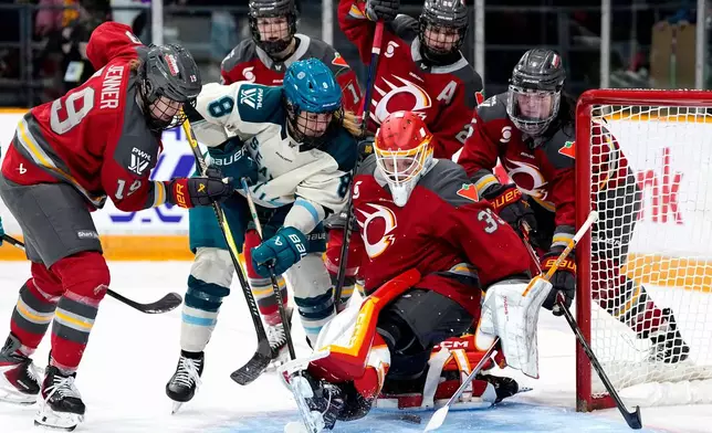 Ottawa Charge goaltender Gwyneth Philips (33) makes the save as Seattle Torrent's Natalie Snodgrass (8) looks for the puck during second period PWHL hockey action in Ottawa, on Wednesday, April 8, 2026. (Justin Tang/The Canadian Press via AP)