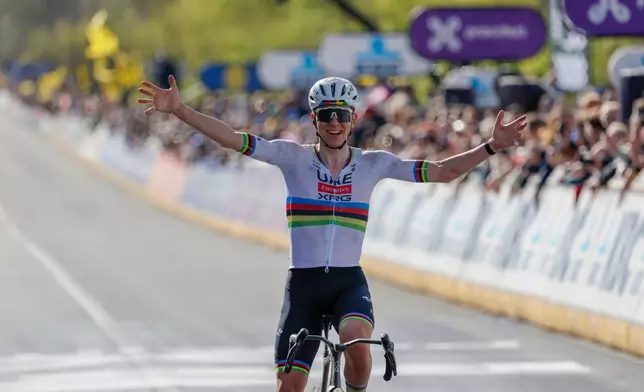 Slovenia's Tadej Pogacar crosses the finish line to win the Tour of Flanders cycling race, in Oudenaarde, Belgium Sunday, April 5, 2026. (AP Photo/Geert Vanden Wijngaert)