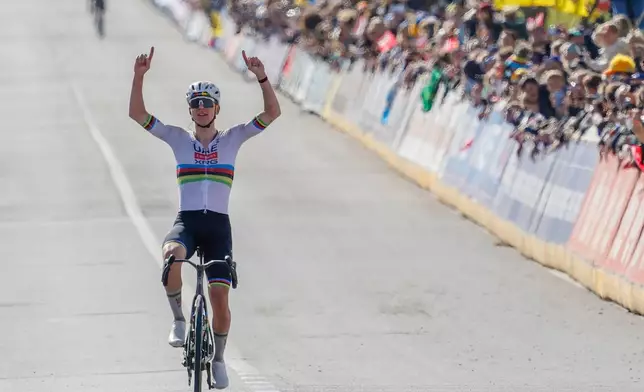 Slovenia's Tadej Pogacar crosses the finish line to win the Tour of Flanders cycling race, in Oudenaarde, Belgium Sunday, April 5, 2026. (AP Photo/Geert Vanden Wijngaert)
